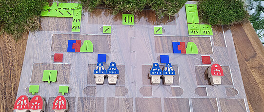 Auf dem Bild ist die Legeplatte für den Entscheidungsbaum zu stehen. Es sind bereits einige der Pilze entsprechend den fühlbaren Eigenschaften angeordnete. Mit kleinen Plättchen sind die Entscheidungsmöglichkeiten tastbar markiert.